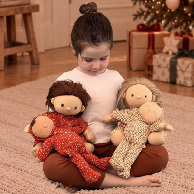 Baby holding Dozy and Dinkum Dolls in PJs