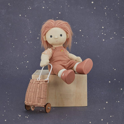 Olli Ella rose rattan doll luggy beside a seated soft doll on a wooden box against a starry navy backdrop