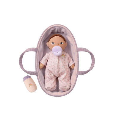 Tiny Binky Dinky doll in pink floral pajamas and pacifier resting in a soft pink carrycot beside a matching rainbow sock from Dinkum Dolls by Olli Ella