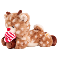 Fluffy plush reindeer with fawn fur and cream spots, a red nose, a smiling cream muzzle, short brown corduroy antlers and hooves, and an embroidered paw-and-rainbow motif on one foot, sitting beside a red and white striped hat.