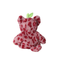 Back view of a soft cherry red cheetah plush doll with darker spots rounded ears and a green leaf detail on its head by Olli Ella