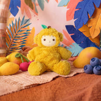 Yellow plush monkey doll seated among mangoes blueberries and tropical leaves from Dinkum Dolls by Olli Ella for imaginative play