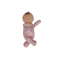 Baby doll in a floral outfit on a white background