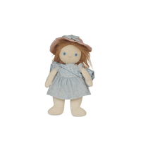 Stuffed doll with a blue dress and pink hat on a black background