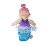 A mermaid doll viewed from the back, featuring pink hair in a bun, a purple top, a blue scale-patterned tail, and a translucent white skirt, set against a plain white background.