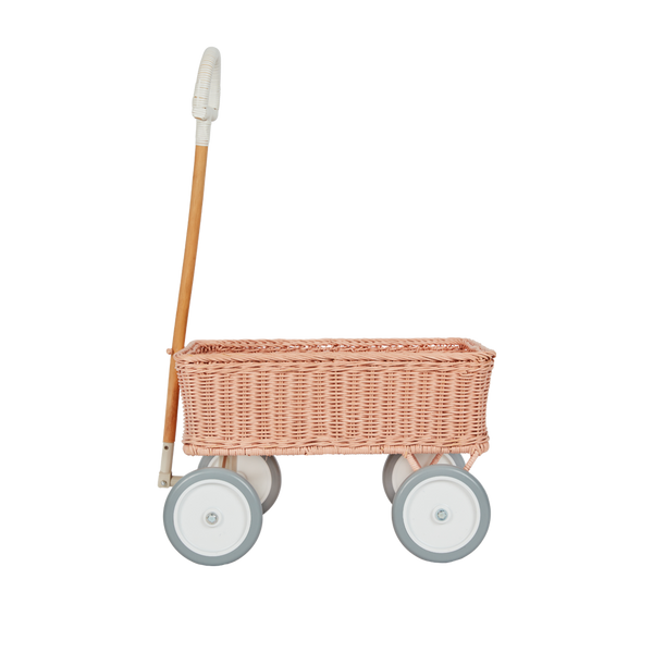 Rose rattan Wonder Wagon by Olli Ella with a woven basket body wooden handle and four pale wheels for imaginative play