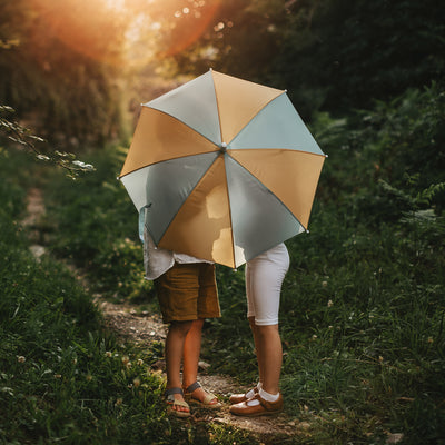 Olli Ella Umbrella in Blue Butter colour way with children hiding behind