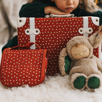 Olli Ella Kids Sweetheart Red wash bag beside a matching suitcase and soft bunny toy as a child prepares for travel