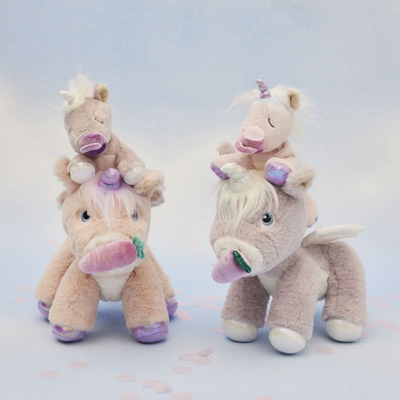 Two plush unicorn toys with tiny unicorn companions enjoy pastel velvet carrot pretend treats from Dinkum Pets in a dreamy play scene