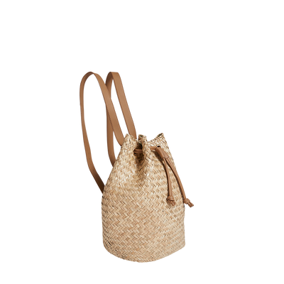 Handwoven natural seagrass backpack with tan leather straps and drawstring closure by Olli Ella Home