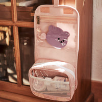 Open pink children's wash bag with a clear pocket holding a purple character accessory and a zipped mesh compartment for toiletries by Olli Ella Kids